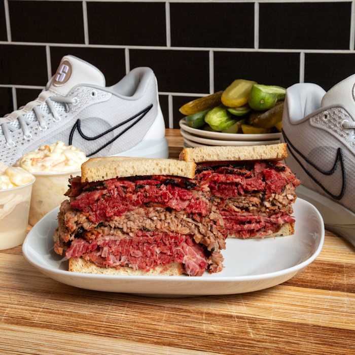 Sabrina Ionescu's white Nike shoes next to a deli sandwich.